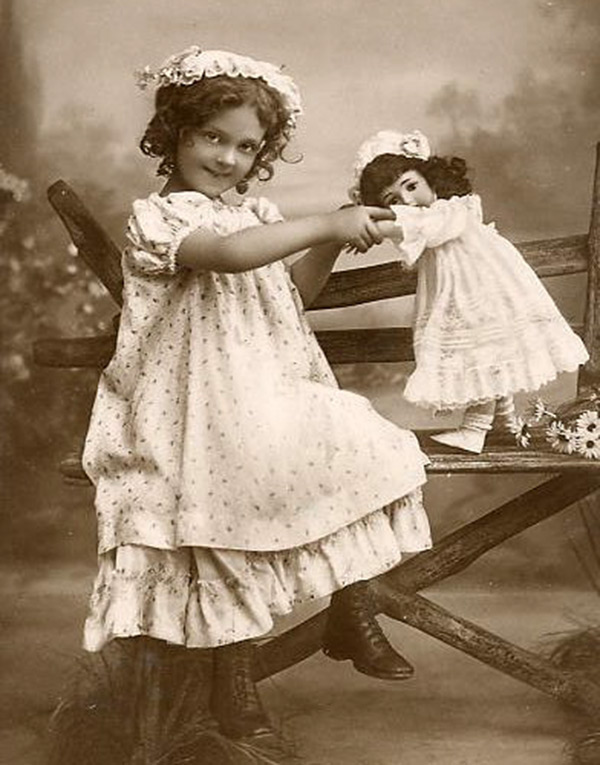 Fille jouant avec une poupée - photo vintage